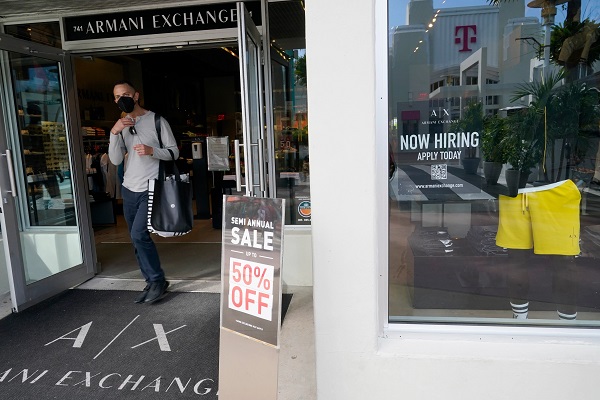 For sale and hiring signs are displayed at an Armani Exchange store on Jan. 21 in Miami Beach. In a buoyant sign for the U.S. economy, businesses stepped up their hiring last month as omicron faded and more Americans ventured out to spend at restaurants, shops and hotels despite surging inflation. (data-c-credit: Marta Lavandier, AP)