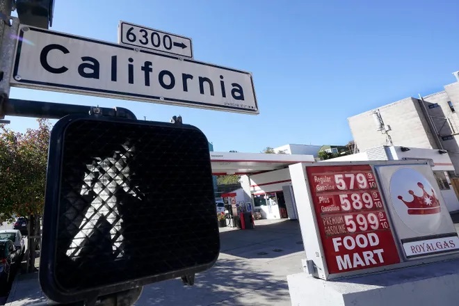 A California street sign is shown next to the price board at a gas station in San Francisco on March 7. The average U.S. price of regular-grade gasoline shot up 79 cents over the past two weeks to $4.43 per gallon. Industry analyst Trilby Lundberg of the Lundberg Survey says gas prices are likely to remain high in the short term as crude oil costs soar amid global supply concerns following Russia's invasion of Ukraine. (data-c-credit=Jeff Chiu, AP)