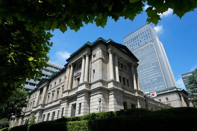 A Japanese flag flutters at the Bank of Japan headquarters in Tokyo on July 29, 2022. The Bank of Japan has held its benchmark interest rate below zero to stimulate growth, but rising prices are testing that strategy. (Shuji Kajiyama, AP)