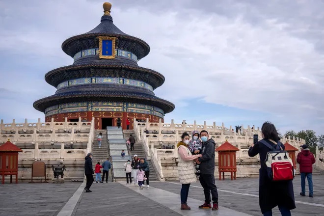 A family poses for photos at the Temple of Heaven in Beijing on Nov. 12, 2022. China has announced its first overall population decline in recent years amid an aging society and plunging birthrate. (Mark Schiefelbein, AP)