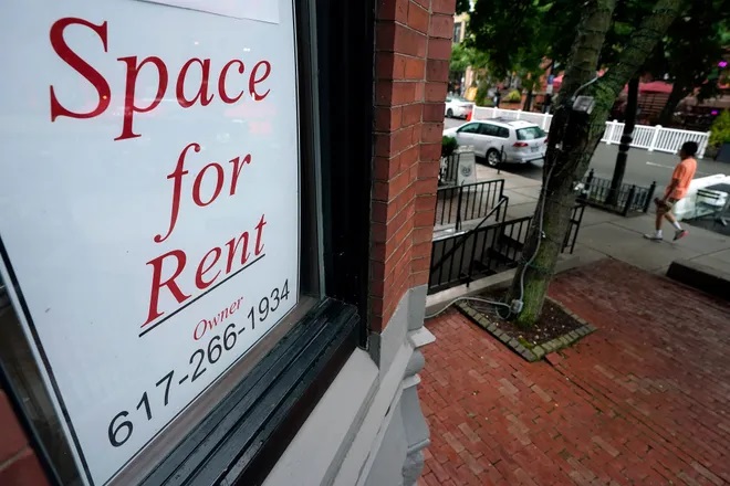 In this Sept. 2, 2020 file photo, a passer-by walks past a business storefront with a space for rent sign in a window in Boston. Business applications were the highest on record in 2020, up 24% from the previous year. You may be considering joining that trend if you don't want to return to an office or were laid off during the pandemic. (AP Photo/Steven Senne)